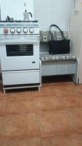 a kitchen with a white stove and a bench at Apartament Alexandru, B-dul Oituz, bloc 4, apartament 26, județ Bacău in Onești