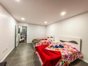 a bedroom with two beds with a red blanket at Bragança Holiday Home new apartment with 2 bedrooms private parking in Bragança