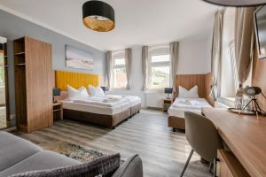 a hotel room with two beds and a couch at ElbApartments - Sächsische Schweiz - Ferienwohnungen zum Malerweg - Bastei Urlaub in Pirna