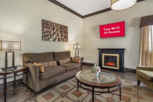 a living room with a couch and a fireplace at Red Roof Inn & Suites Sulphur Springs in Sulphur Springs