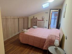 a bedroom with a pink bed and a glass table at Casa Porta Napoli in Castel di Sangro