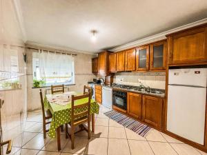 a kitchen with a table and a white refrigerator at Family holiday home new beds in Bragança