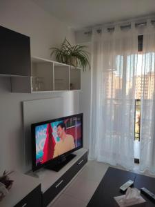 a living room with a flat screen tv in front of a window at Apartamento cerca del centro con parking gratuito in Castellón de la Plana