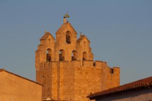 a tall brick tower with a cross on top of it at Appartement "La Rose des Vents" in Saintes-Maries-de-la-Mer