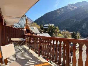 a balcony with a table and a view of a mountain at Appartement Chez Jean - 2 chambres - Centre du Village - À 30 mètres des télécabines in Champagny-en-Vanoise