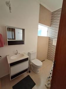 a bathroom with a white toilet and a sink at Recanto das Rosas in Extrema