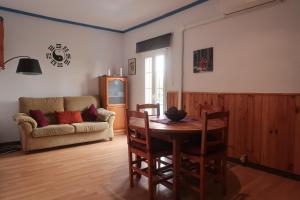 a living room with a table and a couch at Habitaciones Climatizadas Isla Chica in Huelva