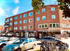 a building with cars and bikes parked in front of it at Gamla Järnvägsgatan 6 in Bollnäs