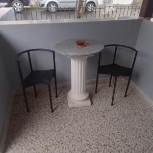 a table with two chairs and a table with a marble top at Suite confortável no centro com Wi fi e TV a Cabo in Águas de São Pedro