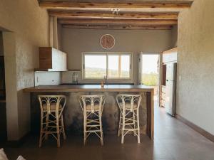 une cuisine avec un comptoir et des tabourets dans une pièce dans l'établissement Villa Atamisque V, à Tupungato 7 autres photos
