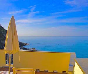 un ombrellone giallo su un balcone con vista sull'oceano di Families or Groups 3 Terrazzi Apartment on Sea w Ac a Vernazza