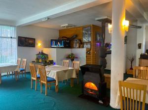 佩奇Hotel Gryka的带桌子和壁炉的餐厅
