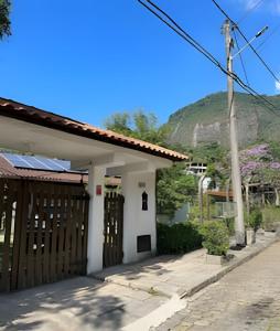 a white house with a mountain in the background at Paraíso Comary-400m CBF-900m feira Alto in Teresópolis +43 photos