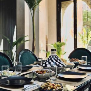 a table with plates and bowls of food on it at Private Riad Alemania in Marrakesh - Pool - Rooftop in Marrakech