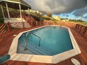 a swimming pool on a deck with a gazebo at Lovely 1bedroom apartment with pool in Christ Church