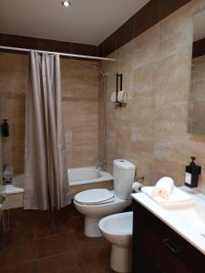a bathroom with a toilet and a tub and a sink at Apartamento Solynieve in Monachil
