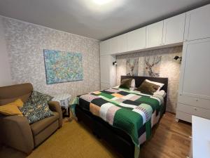 a bedroom with a bed and a chair at KarlovaIdyll 7 - Homey Apartment with FREE Parking! in Tartu