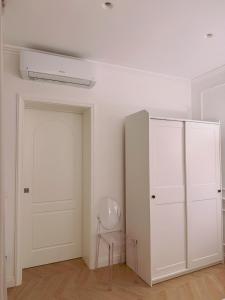 a white room with a white door and a chair at DIMORA CARDUCCI in Bari