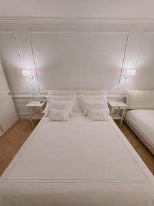 a large white bed in a room with two tables at DIMORA CARDUCCI in Bari