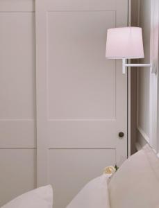 a white room with a lamp and a white couch at DIMORA CARDUCCI in Bari