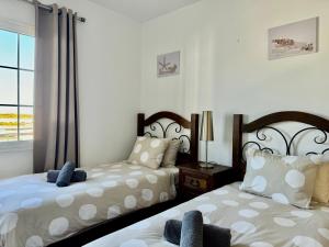 a bedroom with two beds and a window at Casa Marina by Vulcano Homes in Arrieta