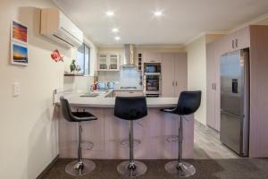 a kitchen with two bar stools and a counter at Close to Beach, Spacious, Outdoor Living - KK00379 in Kaikoura