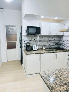 a kitchen with white cabinets and a microwave at Buenos Ayres Apartment in Buenos Aires
