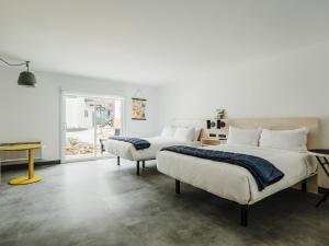 a bedroom with two beds and a table at Field Station Joshua Tree in Yucca Valley