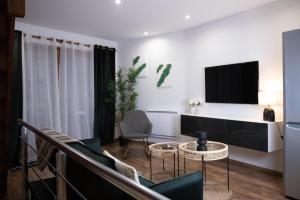 a living room with a couch and a tv at Muraille du château avec jacuzzi in Nemours