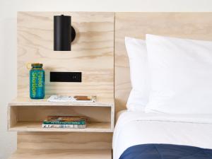 a bedroom with a bed with a nightstand next to it at Field Station Joshua Tree in Yucca Valley