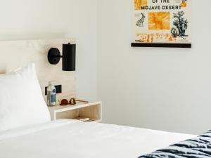 a bedroom with a bed and a poster on the wall at Field Station Joshua Tree in Yucca Valley