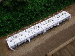 a row of white tables and chairs with flowers on them at Schippershuis in Elahuizen
