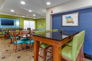 a restaurant with a bar with chairs and tables at Heritage Inn & Suites St Louis Fenton, Trademark by Wyndham in Fenton