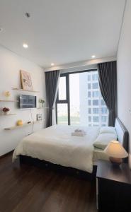 une chambre avec un grand lit et une grande fenêtre dans l'établissement Vinhome Smart City Tây Mỗ Nam Từ Liêm Hà Nội, à Hanoï 32 autres photos