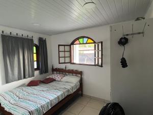 a bed in a room with a window and a bed sidx sidx sidx at Casa de praia seca in Araruama +9 photos