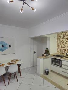 une cuisine avec une table et une cuisinière four supérieur dans l'établissement Apartamento em Santos no Gonzaga em frente a praia, à Santos