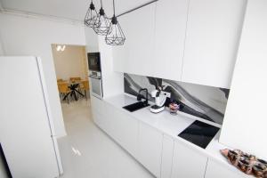 una cucina bianca con elettrodomestici in bianco e nero di Central Lux 2 camere-parcare gratuita, check-in cifru a Piteşti