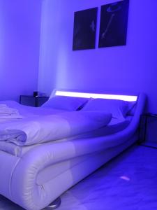 2 letti in una camera con illuminazione viola di Central Lux 2 camere-parcare gratuita, check-in cifru a Piteşti