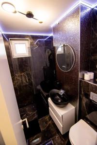 un bagno con un water, un lavandino e uno specchio di Central Lux 2 camere-parcare gratuita, check-in cifru a Piteşti