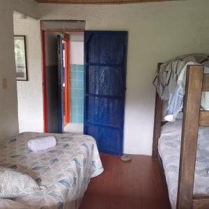 MarsellaにあるAlojamiento Bélgicaの二段ベッド2台と青いドアが備わる客室です。