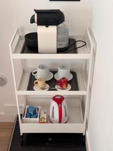ein Küchenregal mit Kaffeemaschine und Tassen in der Unterkunft Alloggio Roma Appia in Rom + 38 Fotos