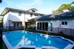 a swimming pool in front of a house at Grand Home Jacuzzi, Heated Pool, Games, BB Court L20 in Miami
