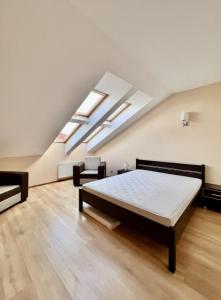 a bedroom with a bed in a room with skylights at Apartament Spacerowa in Grzybowo