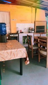 a kitchen with a table and chairs and a stove at Casa Chalé em Shangrilá Pontal do Paraná in Pontal do Paraná