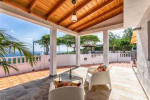 an outdoor patio with a table and chairs at Casa Amanecer I, vistas únicas y paz in Breña Baja