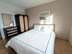a bedroom with a large white bed with two mirrors at Charmante villa avec piscine à 8 minutes d'Uzès in Arpaillargues-et-Aureillac +10 photos