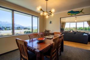 a dining room with a table and chairs and a couch at Close to Beach, Spacious, Outdoor Living - KK00379 in Kaikoura