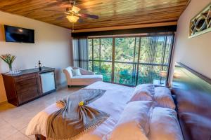 a bedroom with a large bed and a large window at Barons Resort in Atenas