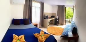 a bedroom with a blue bed with yellow bows on it at Anluka Estudio Yaguarundi in Puerto Jiménez