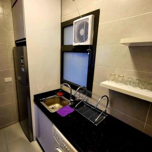 a small kitchen with a sink and a refrigerator at Madinaty Cozy studio at Privado in New cairo +48 photos